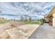 Long driveway leading to tan house with yard, with a cloudy blue sky and green field at 2464 Remington Rd, Elizabeth, CO 80107