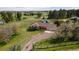 Sprawling ranch-style home with an attached garage, set on a large lot with mature trees and green pastures at 2464 Remington Rd, Elizabeth, CO 80107