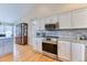 Updated kitchen boasts white cabinets, granite countertops, and stainless steel appliances at 2464 Remington Rd, Elizabeth, CO 80107