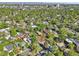 An aerial view captures a neighborhood with lush trees, well-maintained lawns, and the city skyline in the distance at 1431 S Glencoe St, Denver, CO 80222