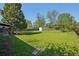 Spacious backyard with a lush lawn, mature trees, and a storage shed providing ample outdoor space and storage at 1431 S Glencoe St, Denver, CO 80222