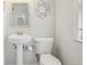 Clean bathroom featuring a pedestal sink, toilet, and decorative flower accent at 1431 S Glencoe St, Denver, CO 80222