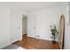 Bright bedroom with hardwood floors, a decorative plant, and open doorways providing access to other areas at 1431 S Glencoe St, Denver, CO 80222