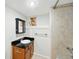 Updated bathroom featuring a granite countertop, wood cabinets, and a tiled shower with a stained glass window at 1582 Steele St, Denver, CO 80206