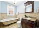 Bathroom with claw foot tub, tiled walls, and granite vanity at 1582 Steele St, Denver, CO 80206