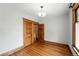 Bedroom featuring wood floors, decorative light fixture, and wooden door with ornate trim at 1582 Steele St, Denver, CO 80206