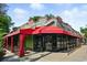Unique restaurant exterior with a red awning, bright signage, large glass windows, and outside seating at 1582 Steele St, Denver, CO 80206