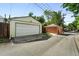 Two car garage with white door and adjacent to a brick outbuilding at 1582 Steele St, Denver, CO 80206