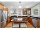 Spacious kitchen with stainless steel appliances, granite countertops, and wood cabinetry at 1582 Steele St, Denver, CO 80206