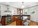 Well-lit kitchen with stainless steel appliances, granite countertops, and a functional island at 1582 Steele St, Denver, CO 80206