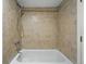 Neutral tile surrounds the bathtub with updated showerhead and fixtures at 1582 Steele St, Denver, CO 80206