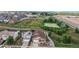 Aerial view of houses and homes in a suburban neighborhood next to a large grassy area and a pond at 169 Westin Ave, Brighton, CO 80603