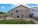 Backyard view of a tan-colored two-story home with sliding glass door and fenced-in area at 169 Westin Ave, Brighton, CO 80603