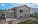 Tan-colored two-story home with sliding glass door, concrete patio, and chain-link fenced-in area at 169 Westin Ave, Brighton, CO 80603