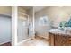 Bright bathroom featuring a glass shower, double sink vanity, and natural light from a window at 169 Westin Ave, Brighton, CO 80603
