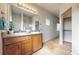 Bright bathroom with a double sink vanity, large mirror, shower with glass door and access to hall at 169 Westin Ave, Brighton, CO 80603