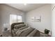 Stylized bedroom features a neutral palette, plush bedding, and ample natural light from a bright window at 169 Westin Ave, Brighton, CO 80603
