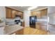 Functional kitchen featuring wood cabinets, granite countertops, modern appliances, and hardwood flooring throughout at 169 Westin Ave, Brighton, CO 80603