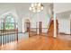 Elegant foyer showcasing hardwood floors, a grand chandelier, and a staircase to the upper level at 15916 E Crestridge Pl, Centennial, CO 80015