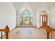 Spacious living room with a large arched window and adjacent front door at 15916 E Crestridge Pl, Centennial, CO 80015