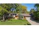 Charming single-story home features a brick facade, lush lawn, mature trees, and a two car garage at 255 Kiowa Pl, Boulder, CO 80303