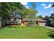Charming single-story home features a brick facade, lush lawn, mature trees, and a two car garage at 255 Kiowa Pl, Boulder, CO 80303
