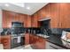 Modern kitchen with wooden cabinets, stainless steel appliances, and stylish black tiled backsplash at 1700 Bassett St # 409, Denver, CO 80202