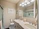 Bright bathroom featuring a dual sink vanity, decorative mirrors and sconces, and a glass enclosed shower with tile accents at 10883 E 163Rd Ct, Brighton, CO 80602