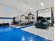 Spacious garage featuring a car lift, RV and classic car on a blue and white painted epoxy floor at 10883 E 163Rd Ct, Brighton, CO 80602