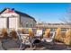 Outdoor firepit with comfortable seating and a view of the garage with white fence at 10883 E 163Rd Ct, Brighton, CO 80602