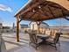 The covered patio features comfortable seating around a fire pit, perfect for outdoor entertaining and relaxation at 10883 E 163Rd Ct, Brighton, CO 80602