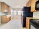 Functional kitchen featuring tile flooring, light wood cabinets, black appliances, and granite countertops at 21993 E Jamison Pl, Aurora, CO 80016