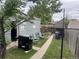 A backyard featuring a grill, two chairs, a garden bed, a purple trash can and a walking path at 188 S Dale Ct, Denver, CO 80219