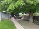 Charming front yard with mature tree, picnic table, and ramp leading to covered porch at 188 S Dale Ct, Denver, CO 80219