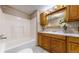Bathroom featuring a tub and shower with updated wooden vanity, sink, and lighting at 8509 Colorado Ct, Denver, CO 80229