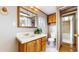 Bathroom with a wood vanity, tile countertop, drawers, mirror and toilet at 8509 Colorado Ct, Denver, CO 80229