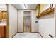 Hallway with tile flooring, utility connections, and access to other rooms in the house at 8509 Colorado Ct, Denver, CO 80229