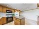 Modern kitchen featuring wooden cabinetry, black appliances, and a kitchen island at 8509 Colorado Ct, Denver, CO 80229