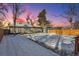 View of backyard from deck; snowy and fenced at 4140 S Inca St, Englewood, CO 80110