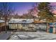 Back of house with patio and snow covered yard at 4140 S Inca St, Englewood, CO 80110