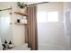 Clean bathroom with floating shelves, a shower curtain, and a well-lit, functional design at 8146 E Harvard Cir, Denver, CO 80231