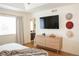 Airy bedroom featuring hardwood floors, stylish dresser with hats, and a glimpse into the en-suite bathroom at 8146 E Harvard Cir, Denver, CO 80231