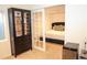 An inviting bedroom view featuring a bed with tufted headboard visible through glass paned doors and a display cabinet at 8146 E Harvard Cir, Denver, CO 80231