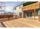 View of the backyard deck with an upper-level covered patio and access to the home through green-framed glass doors at 6758 W Louisiana Pl, Lakewood, CO 80232