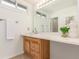 Bright bathroom featuring a wooden vanity, white countertop, large mirror, and modern fixtures at 6758 W Louisiana Pl, Lakewood, CO 80232