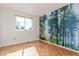 Bright bedroom with hardwood floors and an accent wall of a forest mural at 6758 W Louisiana Pl, Lakewood, CO 80232