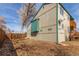 Side view of the home's exterior featuring an upper wood deck, a fenced yard, and a tree at 6758 W Louisiana Pl, Lakewood, CO 80232