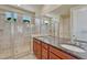 Modern bathroom featuring a double vanity, granite countertops, and a glass-enclosed shower at 8054 E 152Nd Dr, Thornton, CO 80602