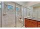 Tiled bathroom with a glass shower door, shower bench, and vanity at 8054 E 152Nd Dr, Thornton, CO 80602