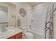Bright bathroom with tiled shower and tub combination, toilet, vanity, and decorative tree wall art at 8054 E 152Nd Dr, Thornton, CO 80602